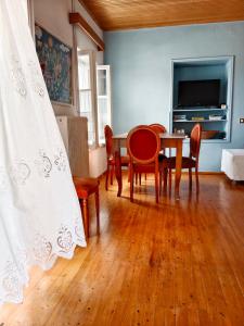 a dining room with a table and chairs and a television at George Traditional House in Pylos