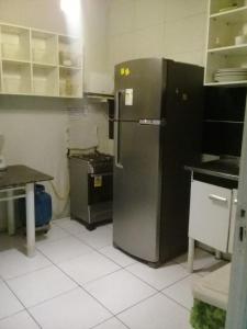 uma cozinha com um frigorífico de aço inoxidável e uma mesa em Hostel Cristo Da Barra em Salvador