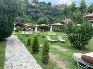 a garden with chairs and tables and umbrellas at Limna Afitos in Afitos