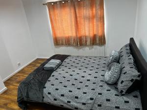 a bedroom with a bed with a black comforter at Good priced double bed in Hayes in Northolt