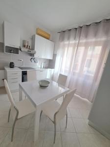 una cucina bianca con tavolo e sedie bianchi di Logudoro Home ad Alghero