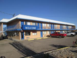 Un edificio con un cartel de bienvenida en un estacionamiento. en Motel 10, en Lordsburg 15 fotos más
