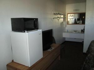 Habitación con TV encima de una nevera. en Motel 10, en Lordsburg