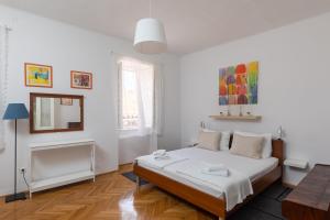 a white bedroom with a bed and a fireplace at Apartman Jelena in Dubrovnik