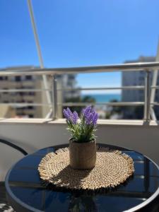 een vaas met paarse bloemen op een tafel bij Breeze Seaview Apartment in Durrës