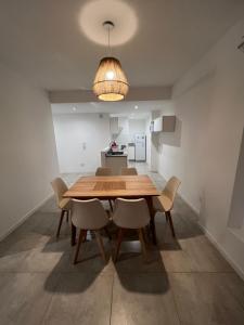 een eetkamer met een houten tafel en stoelen bij Apartamento Mirador de la Viña. in Salta