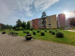 ein Park mit Bänken und Pflanzen und ein Gebäude in der Unterkunft Patogus poilsis prie ežero/Comfortable rest in Visaginas
