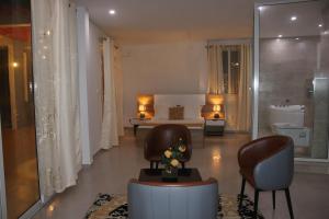 Hary's Aparthotel في توليارا: غرفة معيشة مع كرسيين وغرفة نوم