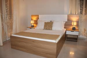 a bedroom with a large bed with two night stands at Hary's Aparthotel in Toliara