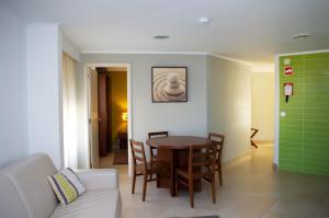 uma sala de estar com uma mesa e um sofá em Apartamentos Vila Nova em Vila Nova de Milfontes