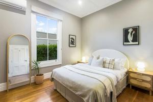 a bedroom with a large bed and a window at Luxury Executive Family Home with Parking & Spa in Auckland