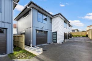 ein Haus mit einer Garage und einer Auffahrt in der Unterkunft Modern Family Townhouse in Mt Roskill, Auckland in Auckland