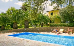 托尔托雷托阿莫尼亚住宿加早餐旅馆的坐在游泳池旁椅子上的家庭