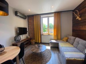 a living room with a couch and a table at Apartamenty ZakopanePoleca - Krupówki Centrum in Zakopane
