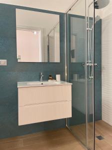 uma casa de banho com um lavatório e um chuveiro em A'mmare Rooms&Apartments Santa Maria di Leuca em Leuca