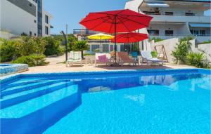 a pool with umbrellas and chairs and a table and chairs and a pool at 6 Bedroom Beautiful Home In Slatine in Slatine