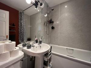 ein Badezimmer mit einem Waschbecken, einer Badewanne und einem Waschbecken in der Unterkunft The Haymarket Flat in Edinburgh