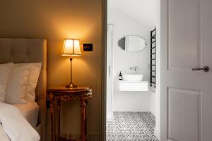 a bedroom with a bed and a table with a lamp at Verandah Cottage B&B 