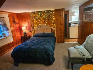 a bedroom with a bed and a chair and lights at Twin Pines Lake House in Gwinn