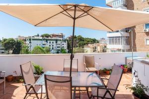 einen Tisch und Stühle mit Sonnenschirm auf dem Balkon in der Unterkunft Apartamento Torremolinos centro in Torremolinos