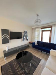 a living room with a blue couch and a table at İnci Sitesi in Tekirdag