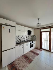 a kitchen with white appliances and a large window at İnci Sitesi in Tekirdag
