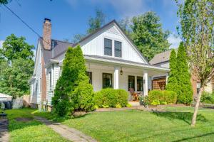 a white house with trees in the yard at Charming Louisville Retreat with Patio and Fireplace! in Louisville