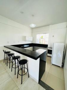 uma cozinha com um balcão e bancos a preto e branco em Hostel Meio do Mundo em Macapá