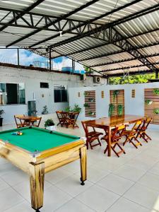 a patio with a pool table and picnic tables at Hostel Meio do Mundo in Macapá