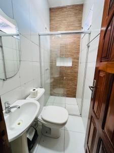 a bathroom with a toilet and a sink and a shower at Hostel Meio do Mundo in Macapá