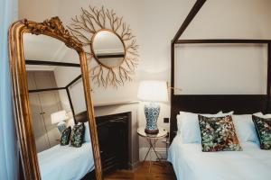 a bedroom with two beds and a mirror at ch1 boutique stays in Chester