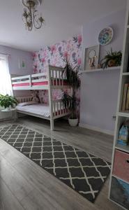 a childs bedroom with a crib and a flower wall at Old School House with Hot Tub in Perth