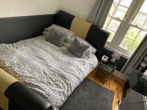 ein Schlafzimmer mit einem Bett mit Kissen darauf in der Unterkunft Quaint Edwardian Cottage in London