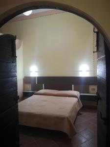 een slaapkamer met een bed en twee lampen aan de muur bij Ai Campanili in San Severo