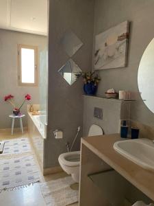 uma casa de banho com um WC, um lavatório e um espelho. em fleur de marrakech em Marrakech