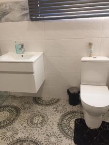 a bathroom with a white toilet and a sink at Beach blessing in Gansbaai
