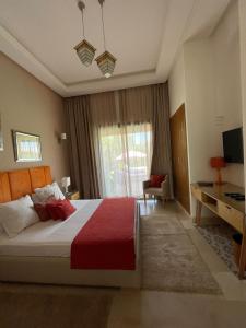 a bedroom with a large bed with a red blanket at fleur de marrakech in Marrakesh