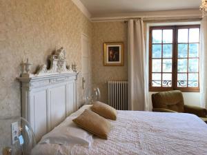 Un pat sau paturi într-o cameră la Hôtel du Moulin