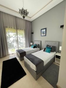 a bedroom with two beds and a chandelier at fleur de marrakech in Marrakesh