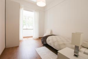リスボンにあるGlamorous Apartment Park Ed VIIの白いベッドルーム(ベッド1台、窓付)