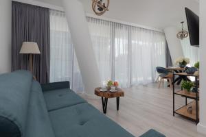 uma sala de estar com um sofá azul e uma mesa em Royal Waves Resort & SPA - Apartment with Parking by Renters em Międzyzdroje