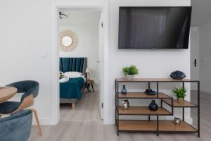 uma sala de estar com uma cama e uma televisão na parede em Royal Waves Resort & SPA - Apartment with Parking by Renters em Międzyzdroje