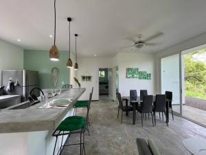 cocina y comedor con mesa y sillas en Green House, en Puntarenas
