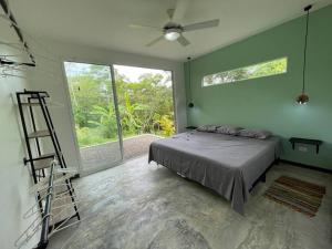 1 dormitorio con cama, escalera y ventana en Green House, en Puntarenas