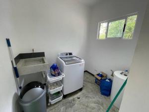 een kleine wasruimte met een wasmachine en droger bij Green House in Puntarenas