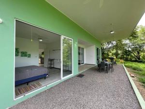 een slaapkamer met een bed en een groot glazen raam bij Green House in Puntarenas