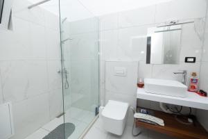 a bathroom with a shower and a toilet and a sink at B&B Bologna Casa Vacanze Vlorë Albania in Vlorë