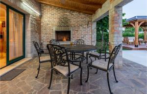 een patio met een tafel en stoelen en een open haard bij Lovely Home In Vir With Wifi in Vir