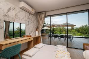 a room with a bed and a view of a patio at Empreo Residence Pool Villa (เอมพรีโอ พูล วิลลา) in Ban Thung Satong