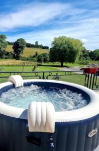 un jacuzzi con sillas blancas en un parque en Villa entiere de 130m2, 2 hectares de nature, en Fruges